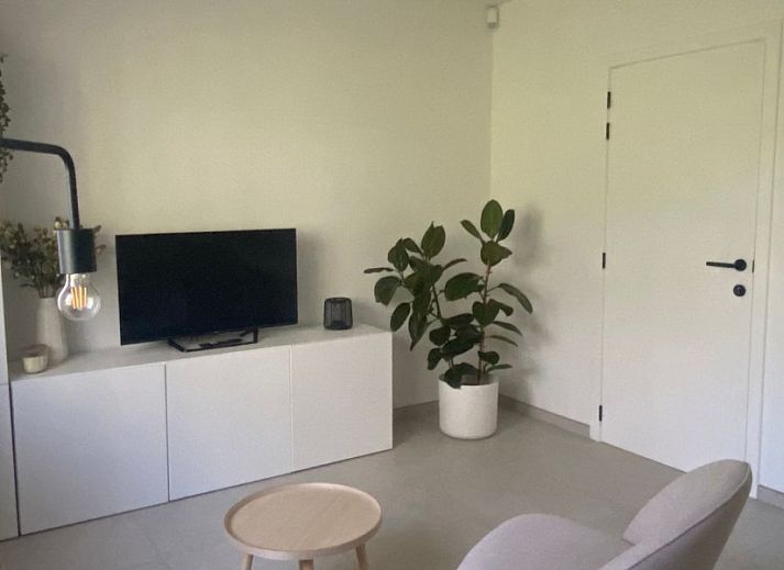Stijlvolle woonkamer in vakantiehuis Ten Huyze Bucholt met comfortabele bank, gelegen in Bocholt, Limburg, Belgie.