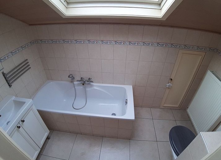 Gezellige woonkamer in De Maaskei vakantiehuis, Kinrooi, Limburg met comfortabele leren banken en een rustieke inrichting.