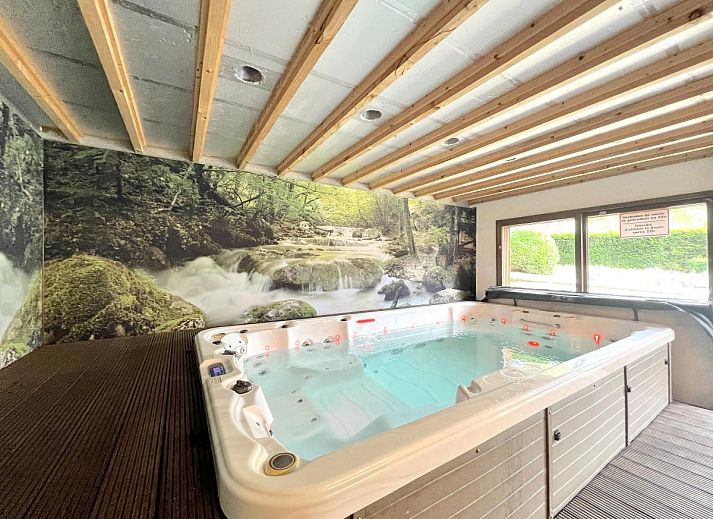 Gemuetliches Wohnzimmer des Ferienhauses Aux Hirondelles in Malmedy, Ardennen, mit grosser Sitzecke.