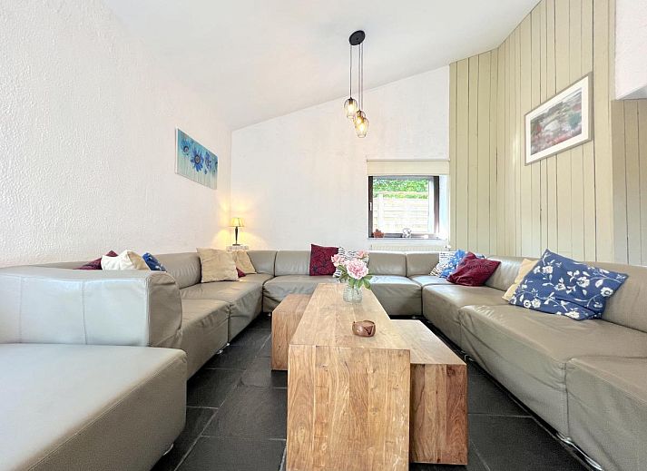 Gemuetliches Wohnzimmer des Ferienhauses Aux Hirondelles in Malmedy, Ardennen, mit grosser Sitzecke.