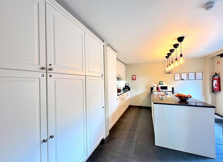 Moderne Kueche des Ferienhauses Aux Hirondelles in Malmedy, Ardennen, mit Bar und Beleuchtung.