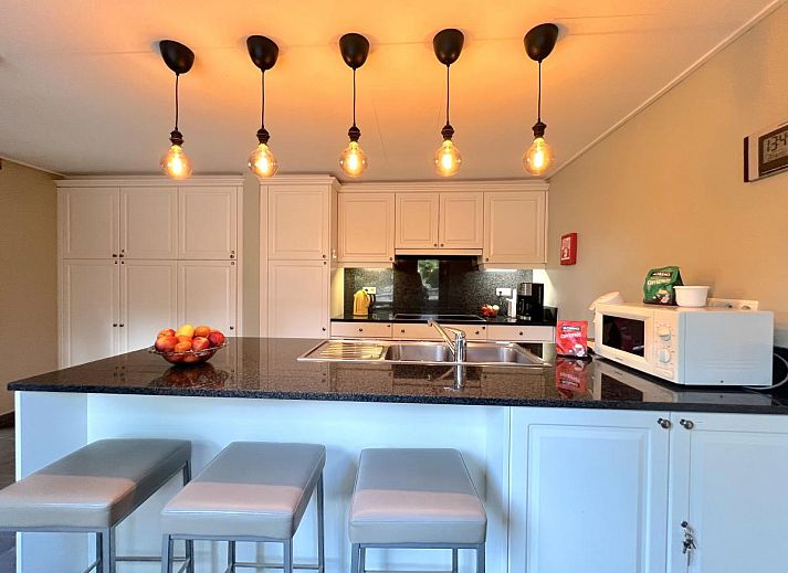 Moderne Kueche des Ferienhauses Aux Hirondelles in Malmedy, Ardennen, mit Bar und Beleuchtung.