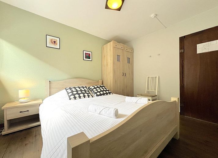 Komfortables Schlafzimmer im Ferienhaus Aux Hirondelles in Malmedy, Ardennen, mit Holzmoebeln.