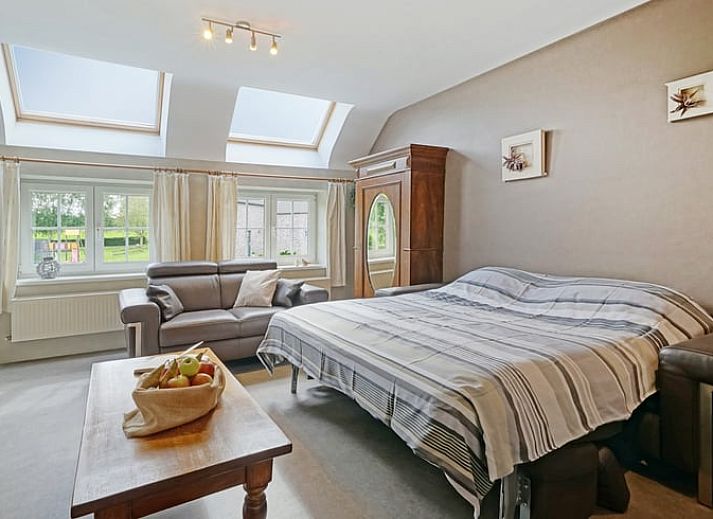 Cozy living room in Holiday Home in Hombourg, Ardennes, with comfortable sitting area and open kitchen, perfect for relaxation in Belgium.