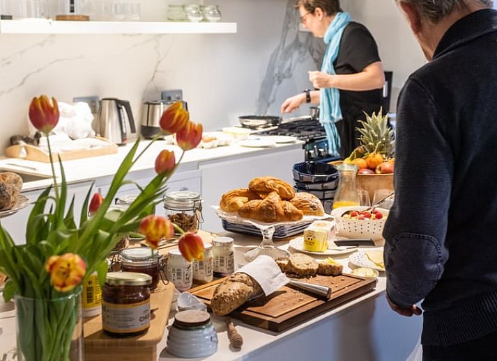 Stijlvolle slaapkamer in Vakantiehuis in Aubel, Ardennen, Belgie, met kleurrijk tapijt en moderne inrichting.