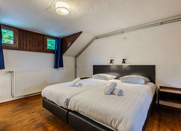 Gezellige woonkamer in Village les Gottales 6-persoons bungalow, Trois-Ponts, Ardennen, met houten balken en knusse open haard.