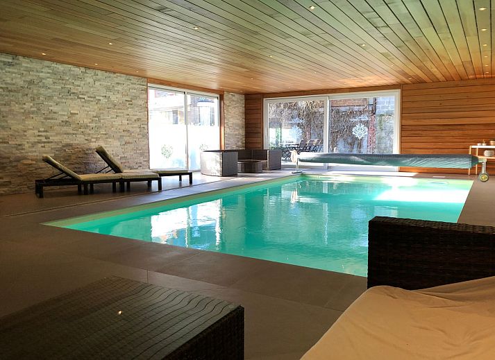 Cozy bedroom in Holiday Home Villa 'Marie France' Wellness, Stavelot, Ardennes, with authentic wooden bed and elegant chairs.