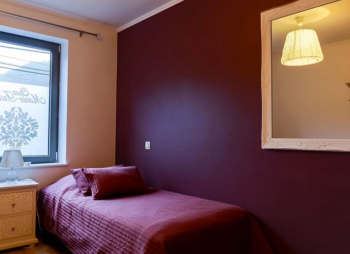 Cozy bedroom in Holiday Home Villa 'Marie France' Wellness, Stavelot, Ardennes, with authentic wooden bed and elegant chairs.