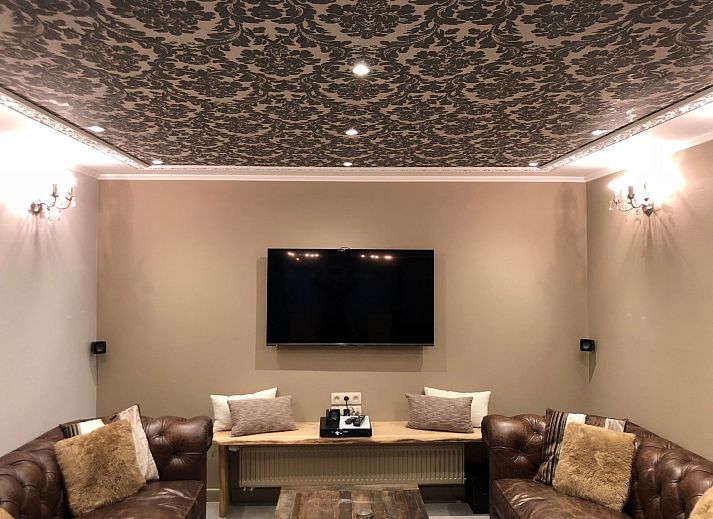 Charming interior of Holiday Home Villa 'Marie France' Wellness in Stavelot, Ardennes, with rustic wooden chest of drawers and decorations.