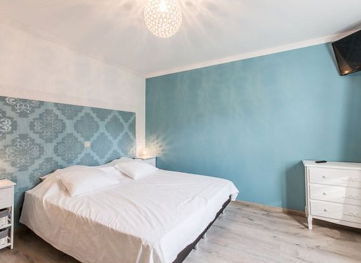 Charming interior of Holiday Home Villa 'Marie France' Wellness in Stavelot, Ardennes, with rustic wooden chest of drawers and decorations.