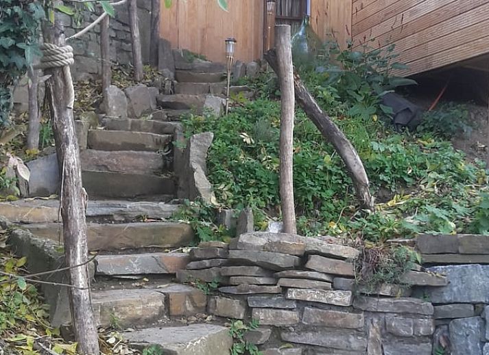 Gemuetliches Schlafzimmer im Ferienhaus in Comblain au Pont, Ardennen, Belgien mit rustikaler Einrichtung und natuerlichen Materialien.