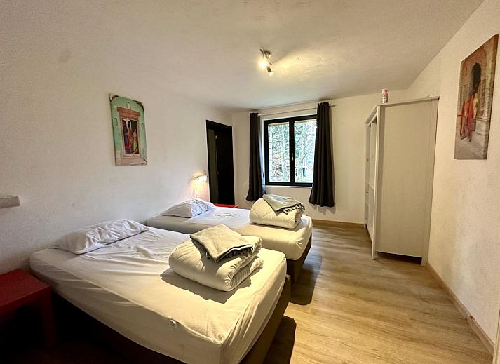 Ruime eetkamer van vakantiehuis Annexe in Sourbrodt, Ardennen, Belgie met lange houten tafel en moderne keuken in de achtergrond.