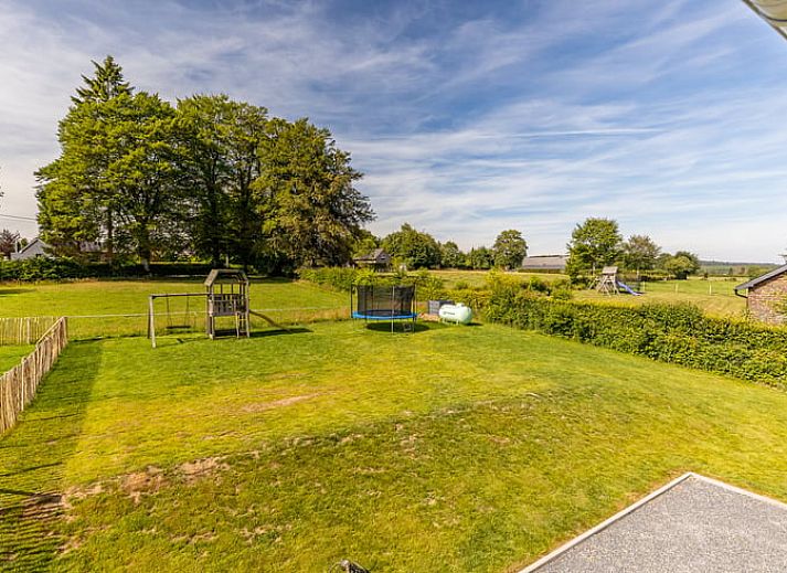 Ruime eetkamer in Vakantiehuisje in Sourbrodt, Ardennen met uitzicht op groene tuin, ideaal voor een ontspannende vakantie in Belgie.