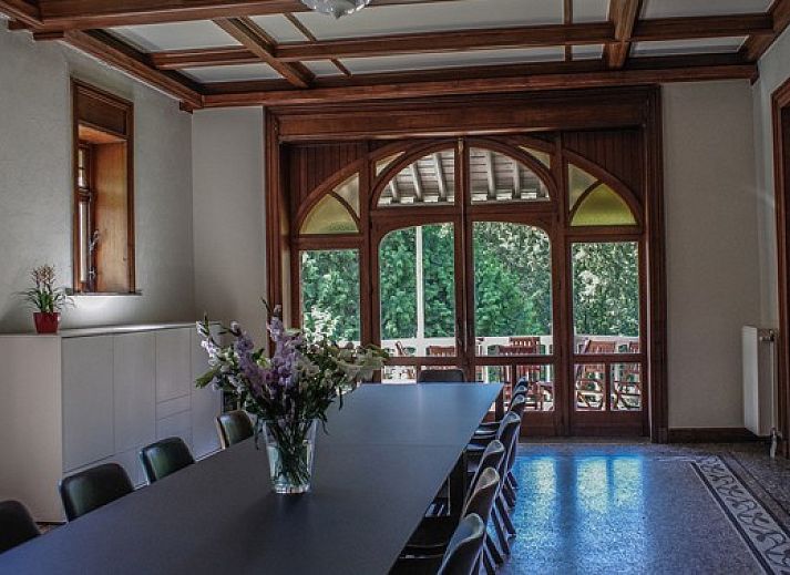Lichte woonkamer in La Merveille de Mery, vakantiehuis in Esneux, met grote ramen en comfortabele bank.