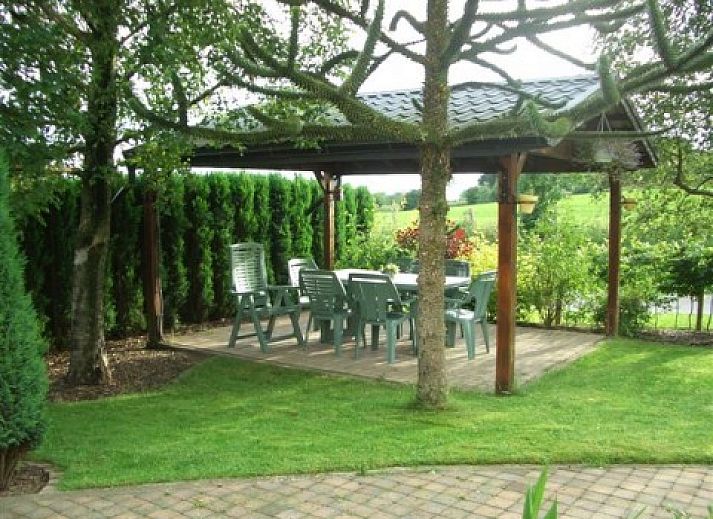 Vooraanzicht van vakantiehuis Zur Krombisch in Elsenborn, Ardennen, met charmante tuin en toegangstrap.