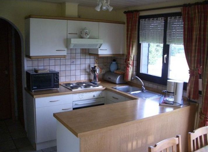 Vooraanzicht van vakantiehuis Zur Krombisch in Elsenborn, Ardennen, met charmante tuin en toegangstrap.