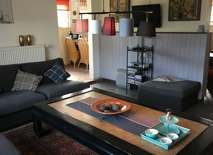 Gezellige veranda van De Eifelhoeve vakantiehuis in Herresbach, Ardennen, Belgie, met blauwe kussens en decoratieve elementen.