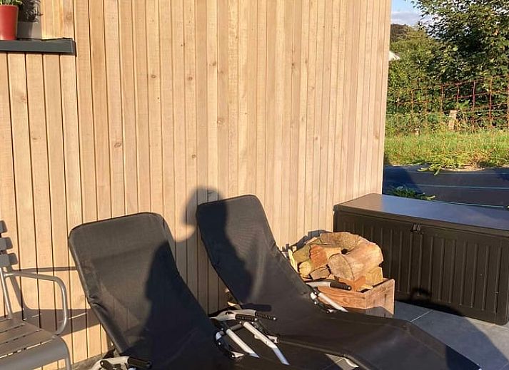 Geraeumiges Ferienhaus im Freien in Spa, Ardennen, Belgien, mit bequemen Liegestuehlen und Blick auf die Natur.