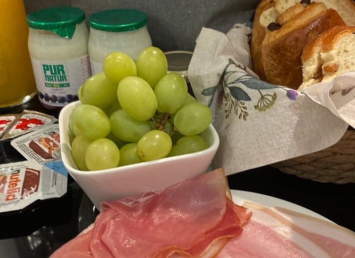 Gemuetliche Sitzecke im Ferienhaus in Spa, Ardennen, Belgien, mit bequemen Stuehlen und Blick auf den Garten.