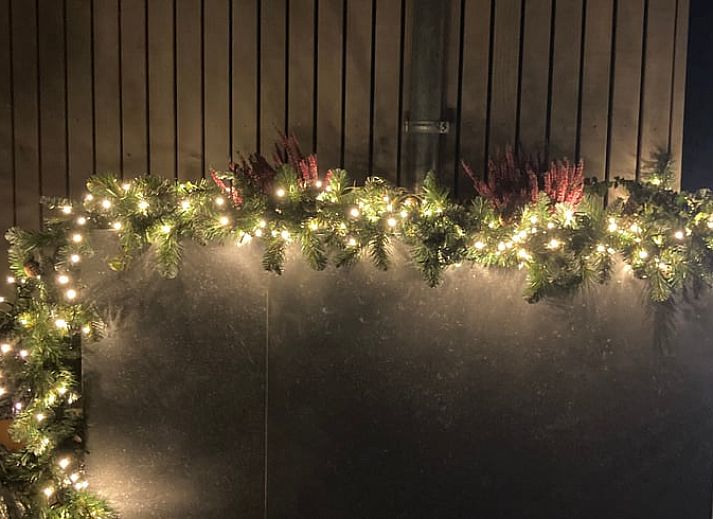Gemuetliche Sitzecke im Ferienhaus in Spa, Ardennen, Belgien, mit bequemen Stuehlen und Blick auf den Garten.