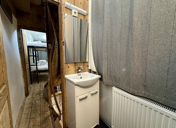 Houten trap in vakantiehuis Le Cent Quarante, Spa, Ardennen. Sfeervolle binnenruimte met unieke decoratie en tegelvloer.