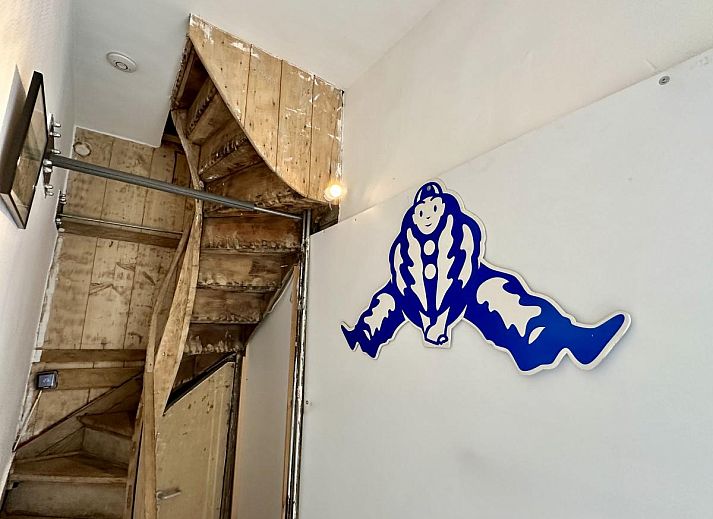 Houten trap in vakantiehuis Le Cent Quarante, Spa, Ardennen. Sfeervolle binnenruimte met unieke decoratie en tegelvloer.