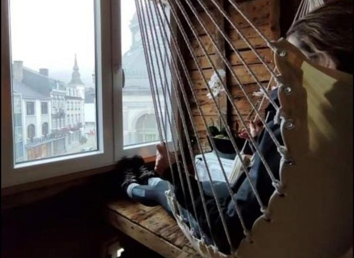 Houten trap in vakantiehuis Le Cent Quarante, Spa, Ardennen. Sfeervolle binnenruimte met unieke decoratie en tegelvloer.