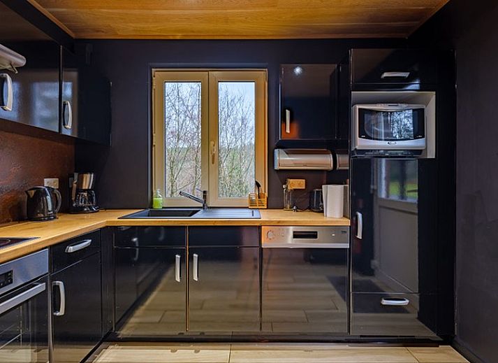 Gemuetliches Wohnzimmer in A LOREE DU BOIS, Ferrieres, Ardennen, mit Holzdecke und stimmungsvoller Beleuchtung.