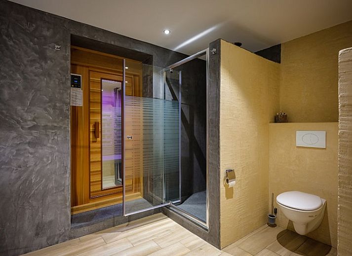 Gemuetliches Wohnzimmer in A LOREE DU BOIS, Ferrieres, Ardennen, mit Holzdecke und stimmungsvoller Beleuchtung.