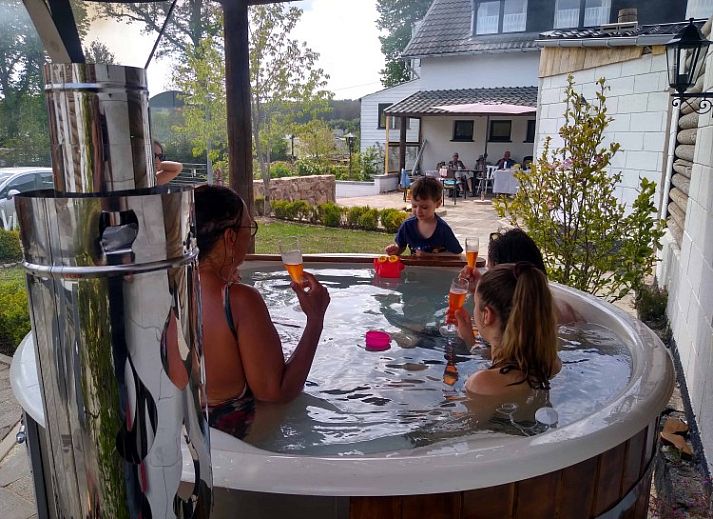 ArdennerHof Ferienhaus in Amel, Ardennen bei Sonnenuntergang mit stimmungsvoll beleuchteter Terrasse.
