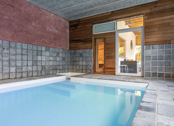 Entree van Huisje in Stoumont, een gezellig vakantiehuis in de Ardennen, Luik, Belgie met een charmante stenen boog en rustieke sfeer.