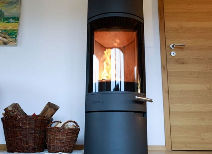 Das Ferienhaus in Kuechelscheid in den Ardennen, Belgien, bietet einen charmanten Aussenbereich mit einem gruenen Garten und einer rustikalen Holzfassade.