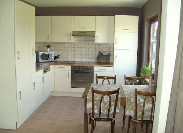 Achtertuin en terras van La Boerderij vakantiewoning in Bois de Lompret, Henegouwen met groene omgeving.