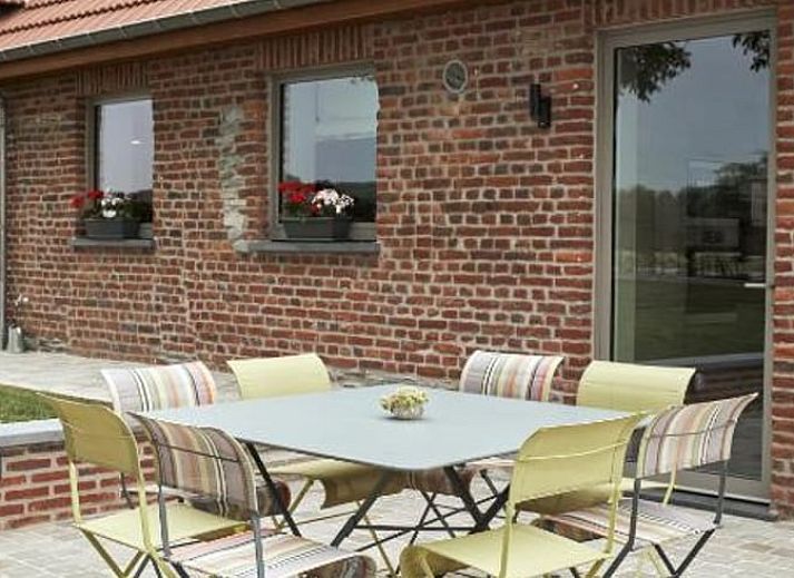 Buiten terras van Vakantiehuisje in Jollain, Henegouwen, Belgie met gezellige zitplek en bakstenen muren.