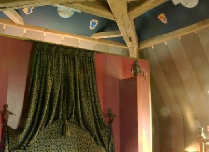 Gemuetlicher Speisesaal im Les Confidences de Messire Sanglier, Beauraing, mit antikem Tisch und stimmungsvoller Beleuchtung.