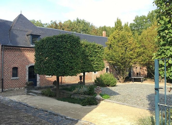 Romantisches Schlafzimmer in Les Confidences de Messire Sanglier, Ferienhaus in Beauraing, mit Holzbalken und Blumenmuster.