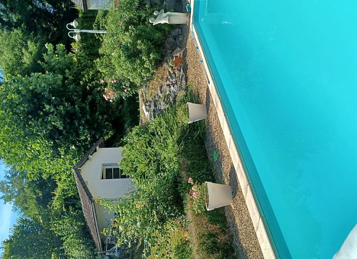 Blick auf das Schwimmbad und die gruene Umgebung des Ferienhauses in Profondeville, Ardennen, Belgien.