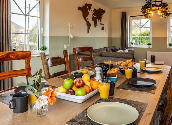 Gezellige woonkamer van Huisje in Bievre, vakantiehuis in de Ardennen, Belgie met comfortabele zitruimte en wereldkaart decoratie.