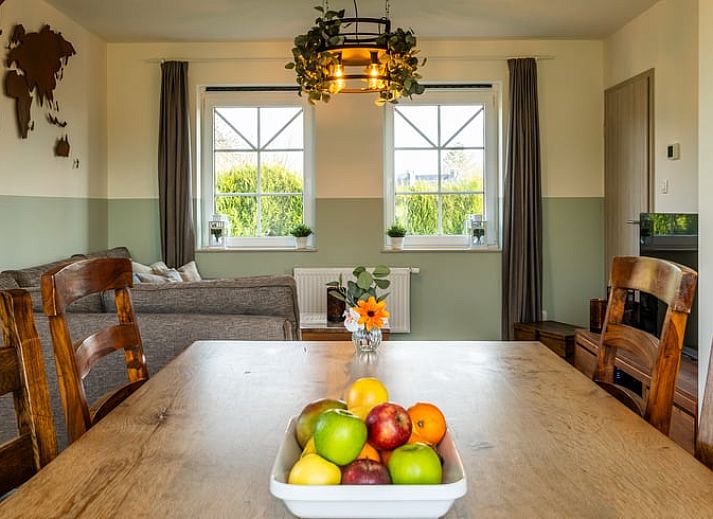 Gezellige woonkamer van Huisje in Bievre, vakantiehuis in de Ardennen, Belgie met comfortabele zitruimte en wereldkaart decoratie.