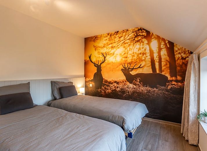 Eetkamer van Huisje in Bievre, vakantiehuis in de Ardennen, Belgie met rijkelijk gedekte tafel en zicht op de tuin.