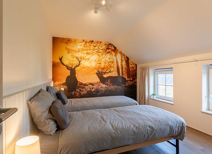 Eetkamer van Huisje in Bievre, vakantiehuis in de Ardennen, Belgie met rijkelijk gedekte tafel en zicht op de tuin.