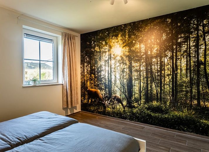 Eetkamer van Huisje in Bievre, vakantiehuis in de Ardennen, Belgie met rijkelijk gedekte tafel en zicht op de tuin.