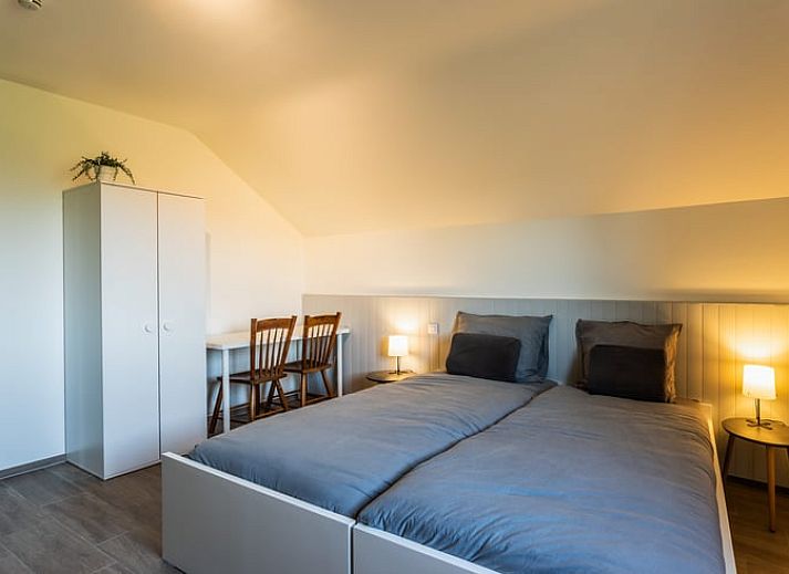 Eetkamer van Huisje in Bievre, vakantiehuis in de Ardennen, Belgie met rijkelijk gedekte tafel en zicht op de tuin.