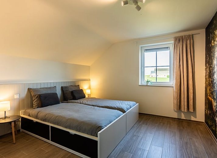 Eetkamer van Huisje in Bievre, vakantiehuis in de Ardennen, Belgie met rijkelijk gedekte tafel en zicht op de tuin.