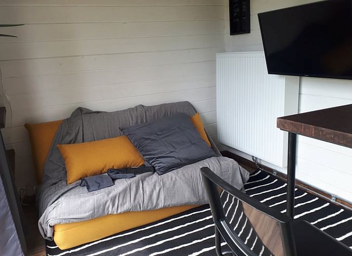 Outdoor area of Cottage in Gesves with fire basket and colorful chairs, vacation home in Ardennes, Belgium.