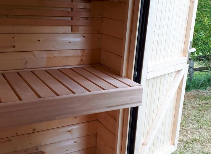 Outdoor area of Cottage in Gesves with fire basket and colorful chairs, vacation home in Ardennes, Belgium.