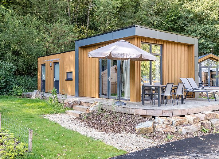 4-persoons lodge 4B1 in Gesves, Ardennen, Belgie met houten terras en omgeven door groene natuur, ideaal vakantiehuis voor ontspanning.