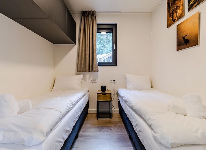 4-persoons lodge 4B1 in Gesves, Ardennen, Belgie met houten terras en omgeven door groene natuur, ideaal vakantiehuis voor ontspanning.