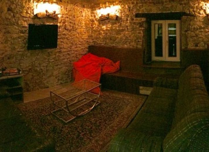 Terrasse von Le Moulin De Romedenne in Philippeville, Ferienhaus in den Ardennen mit gruenen Sonnenschirmen und Holztischen.