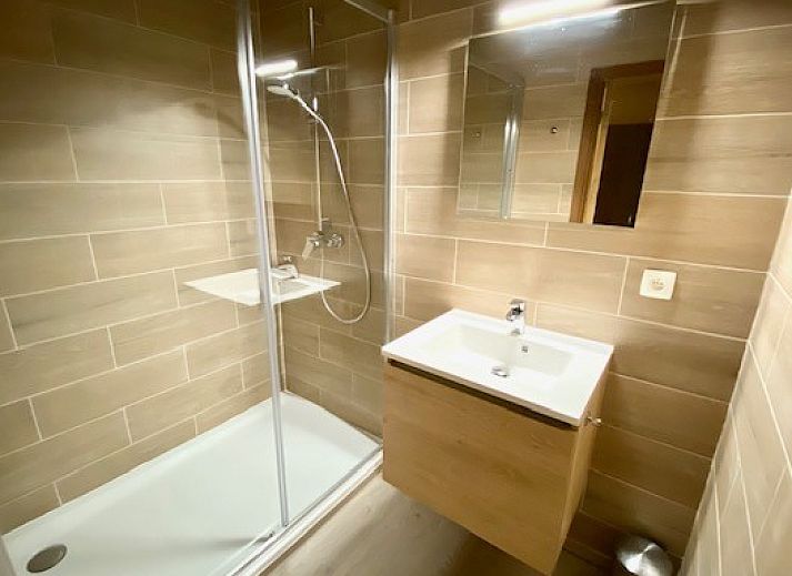 Terrasse von Le Moulin De Romedenne in Philippeville, Ferienhaus in den Ardennen mit gruenen Sonnenschirmen und Holztischen.